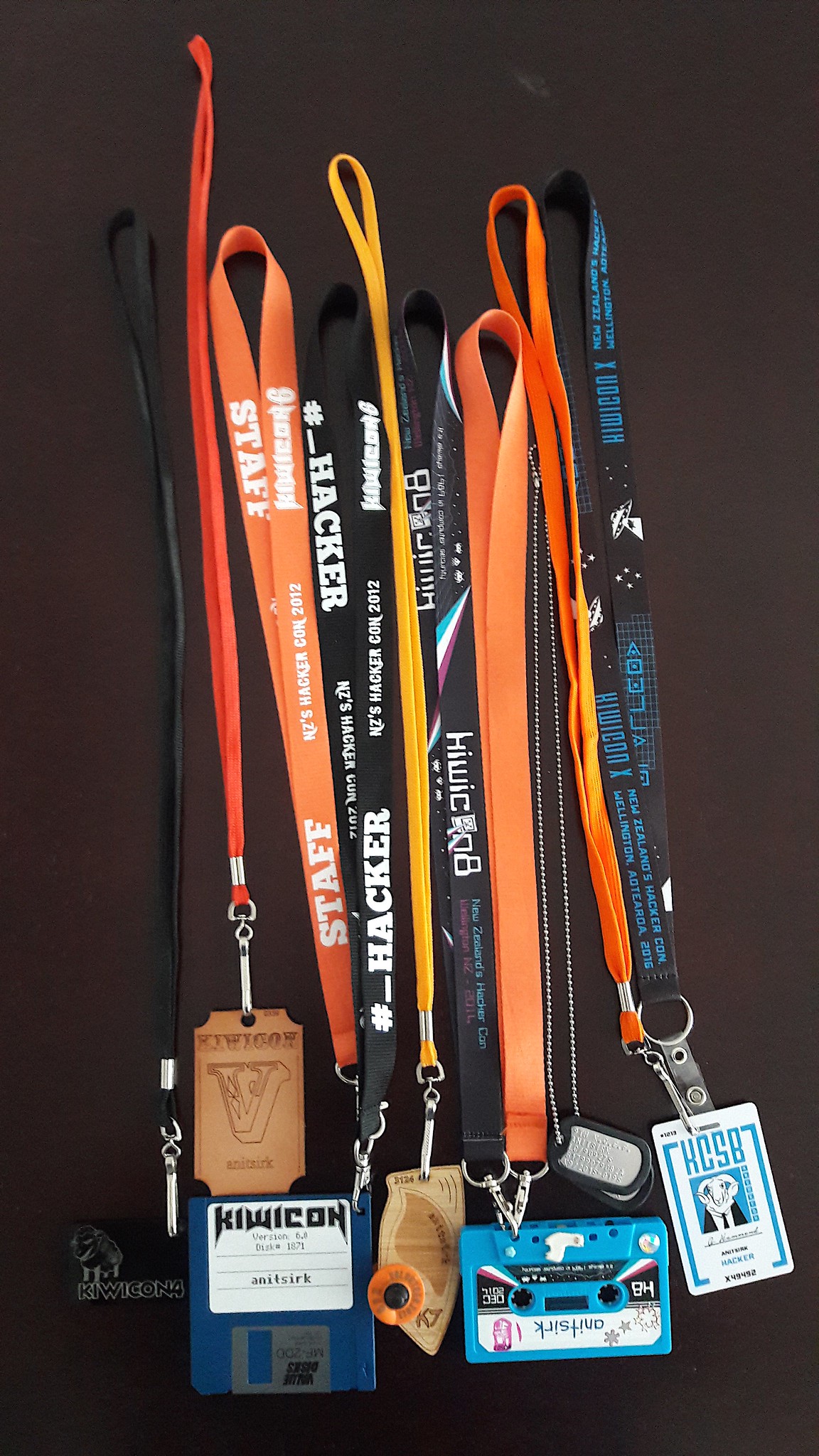 A selection of lanyards and badges for past Kiwicons, hanging vertically