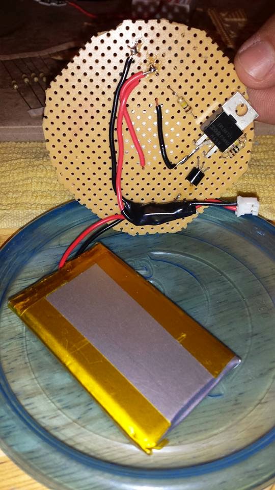Breadboard with flat battery on a tupperware lid.